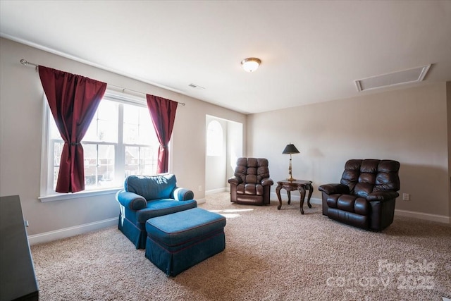 living area featuring attic access, carpet flooring, and baseboards