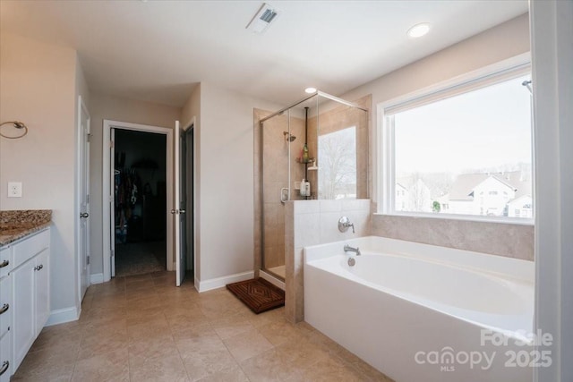 full bath featuring a garden tub, visible vents, a spacious closet, vanity, and a shower stall