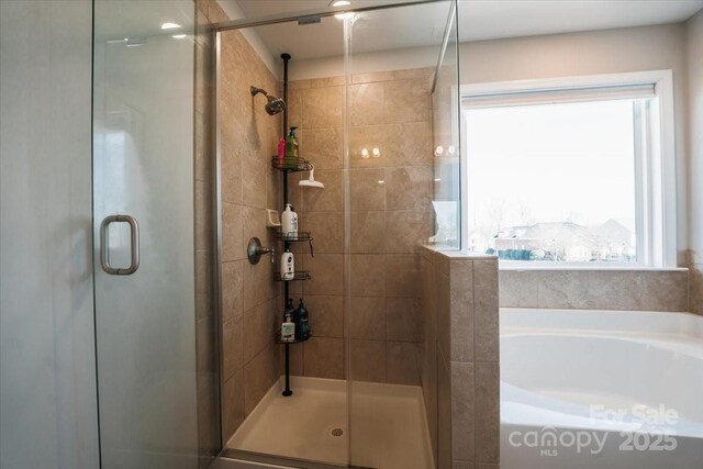 full bathroom with a stall shower and a bath