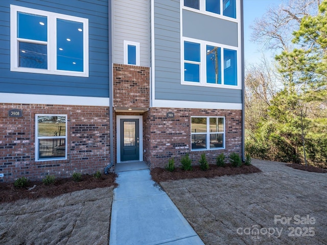 property entrance featuring brick siding