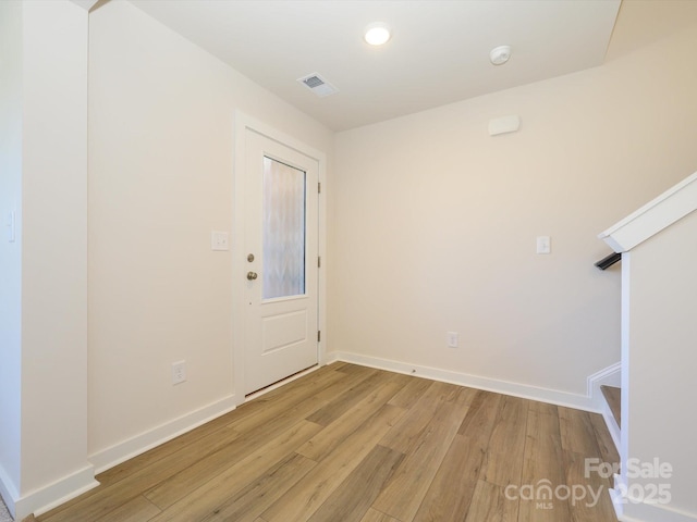 foyer featuring visible vents, baseboards, and light wood-style flooring