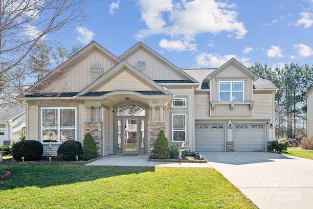 craftsman inspired home featuring an attached garage, concrete driveway, stone siding, a front lawn, and board and batten siding