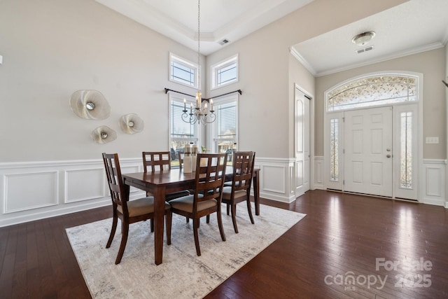 dining space with dark wood-type flooring, visible vents, and a notable chandelier