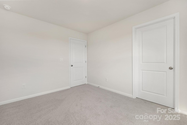 unfurnished room featuring light colored carpet