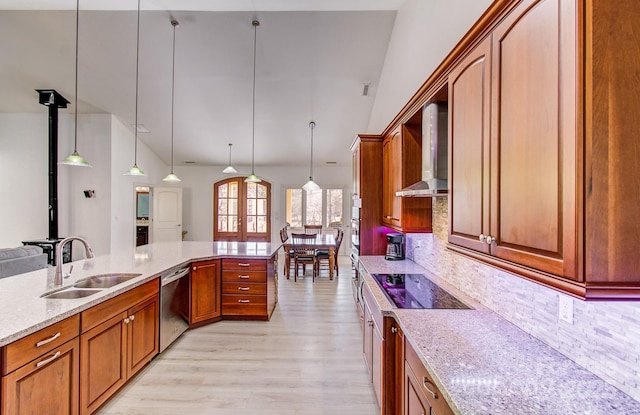 kitchen with pendant lighting, a sink, wall chimney range hood, and stainless steel dishwasher