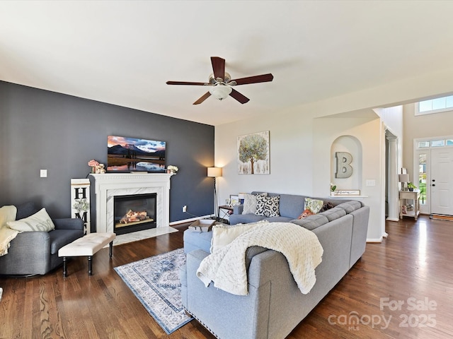 living area with a premium fireplace, baseboards, and dark wood-type flooring