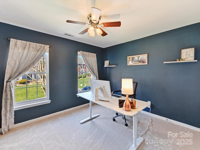 office featuring carpet floors, visible vents, ceiling fan, and baseboards