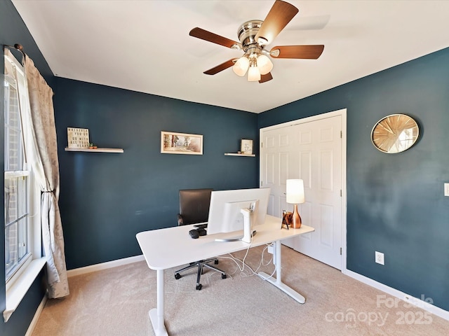 office space with light carpet, ceiling fan, and baseboards