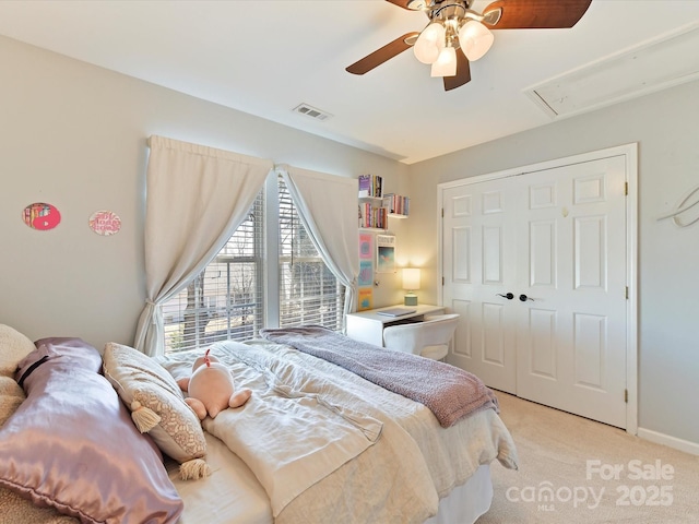 bedroom featuring light carpet, attic access, visible vents, ceiling fan, and a closet