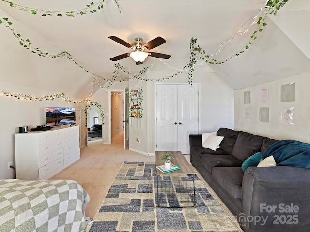 bedroom featuring a ceiling fan, a closet, light colored carpet, and vaulted ceiling