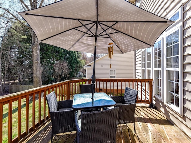 wooden terrace with outdoor dining space and fence