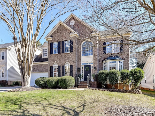 view of front facade featuring driveway, a front yard, and brick siding