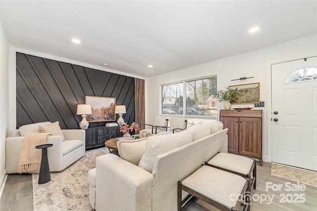 living room featuring light wood-style floors, recessed lighting, and wooden walls