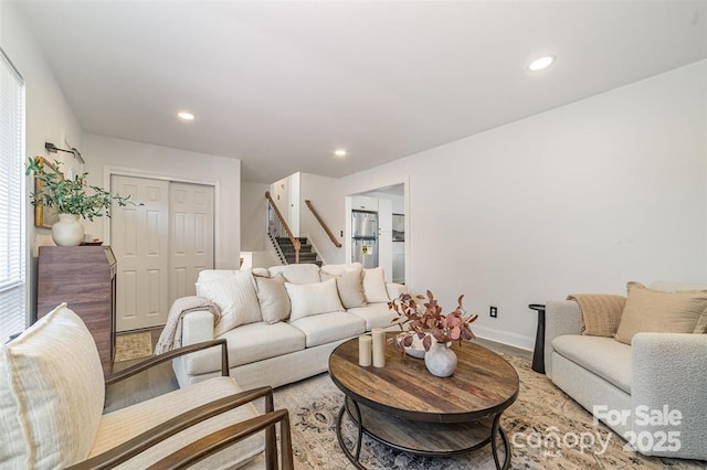 living room with baseboards, stairway, light wood-type flooring, and recessed lighting