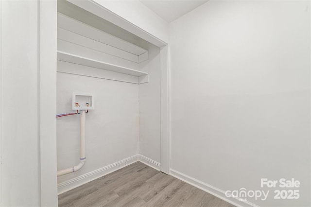 clothes washing area with laundry area, hookup for a washing machine, baseboards, and wood finished floors