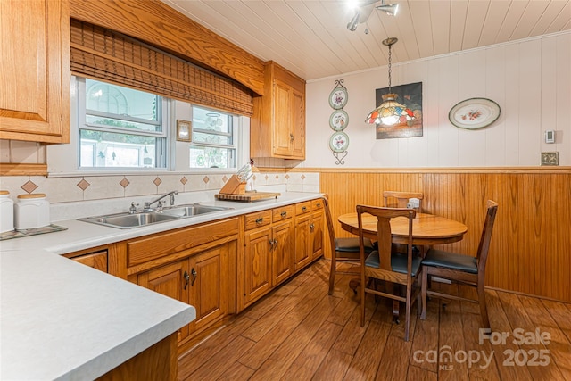 kitchen with wooden ceiling, brown cabinets, hardwood / wood-style floors, light countertops, and a sink