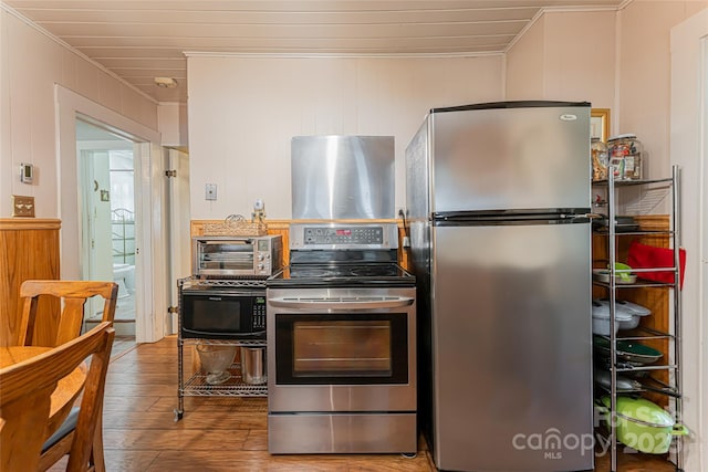 kitchen featuring a toaster, crown molding, appliances with stainless steel finishes, and hardwood / wood-style floors