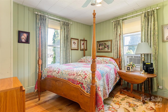 bedroom with ceiling fan, multiple windows, and wood finished floors