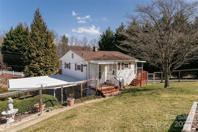 view of front of house featuring a shingled roof, fence, a front lawn, and concrete driveway