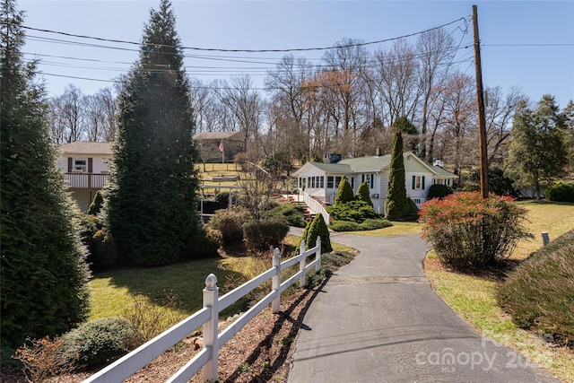 view of front of house with a fenced front yard, a front lawn, and aphalt driveway