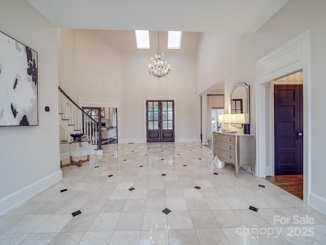 foyer entrance with light tile patterned floors, a notable chandelier, baseboards, stairs, and french doors