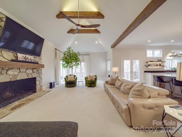 living room featuring a healthy amount of sunlight, carpet, a fireplace, and french doors