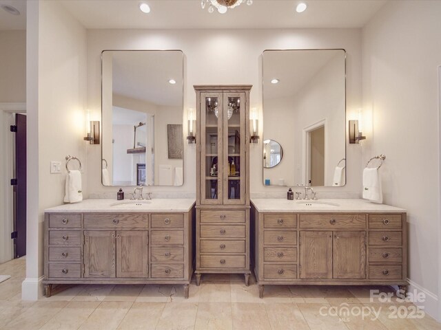 full bath with two vanities, a sink, and recessed lighting