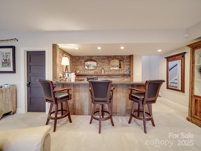 bar featuring a bar, light carpet, baseboards, and recessed lighting