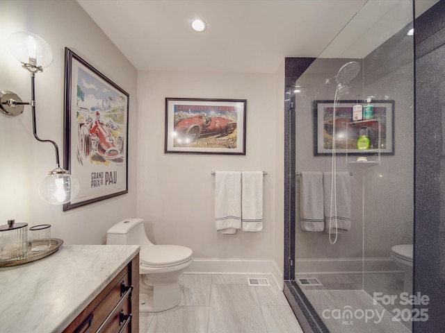 bathroom featuring toilet, baseboards, a walk in shower, and vanity