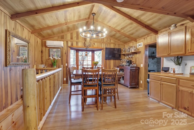 dining space featuring a chandelier, lofted ceiling with beams, wood walls, light wood-type flooring, and a wall mounted air conditioner