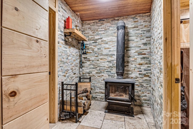 details featuring wooden ceiling and a wood stove