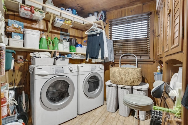 laundry room with laundry area, wooden walls, washer and dryer, and wood finished floors