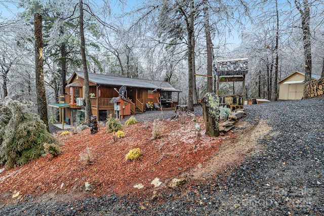 view of front of home featuring a storage shed, a deck, and an outbuilding