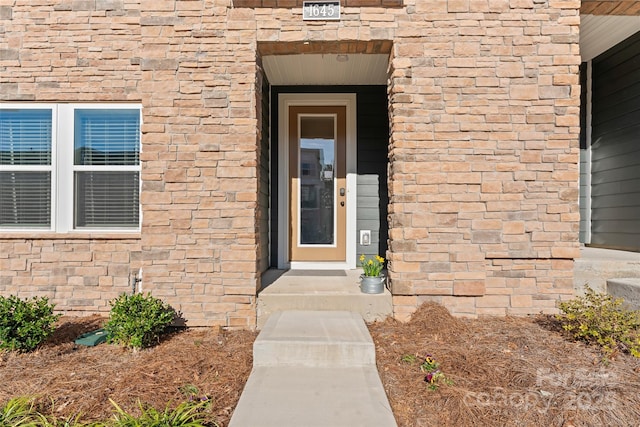 doorway to property featuring brick siding