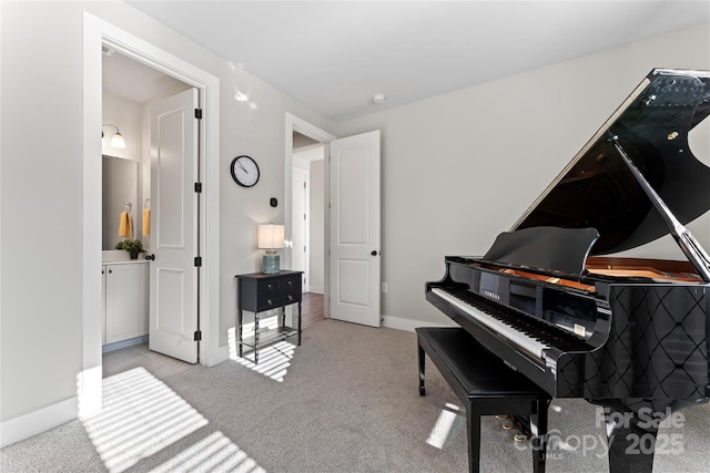 sitting room with baseboards and light colored carpet