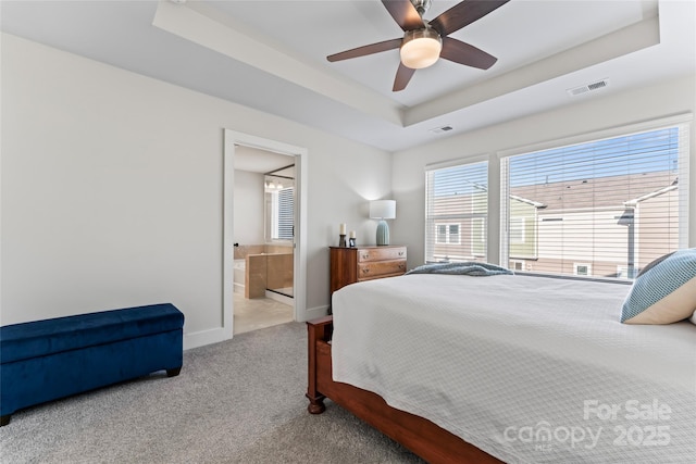 bedroom with carpet floors, baseboards, visible vents, and a raised ceiling