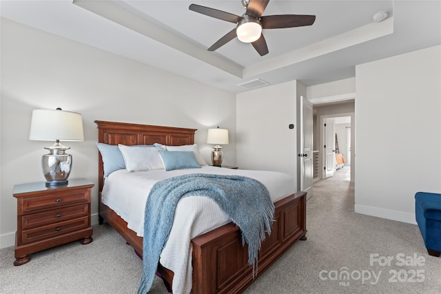 bedroom featuring light colored carpet, a ceiling fan, baseboards, visible vents, and a raised ceiling