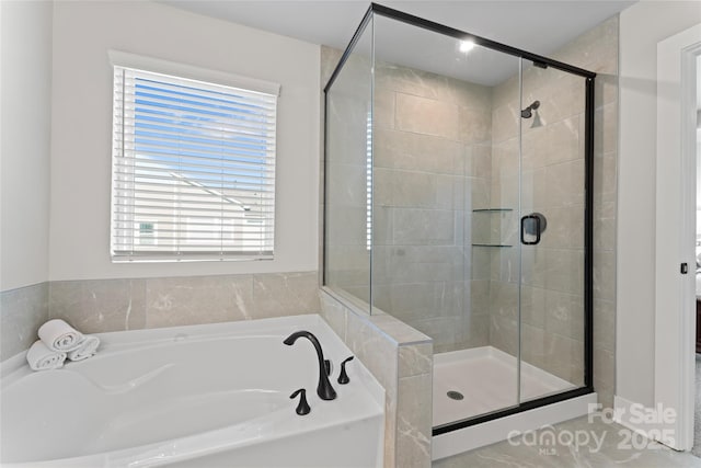 bathroom featuring a stall shower and a bath