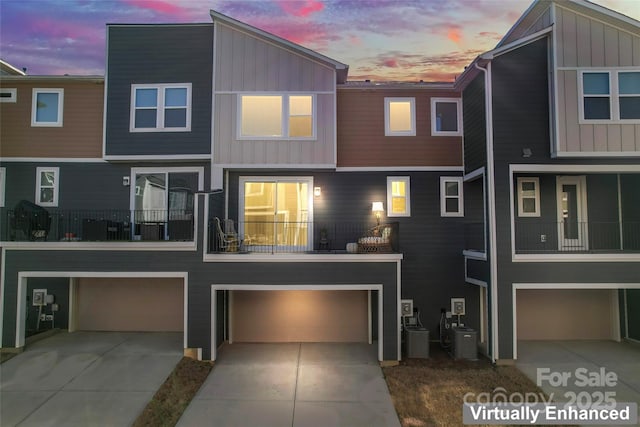 multi unit property featuring a garage, driveway, and board and batten siding