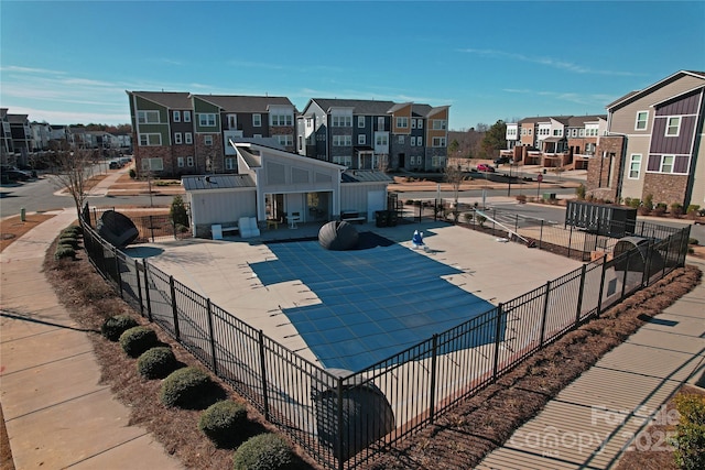 surrounding community with a patio, a swimming pool, fence, and a residential view