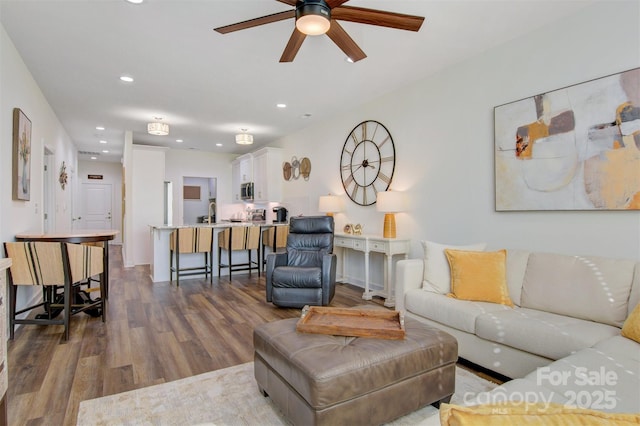 living area with recessed lighting, ceiling fan, and wood finished floors