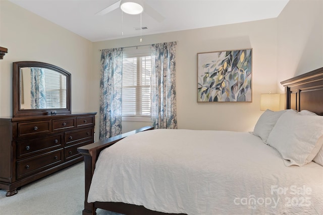 bedroom with light carpet, visible vents, and a ceiling fan