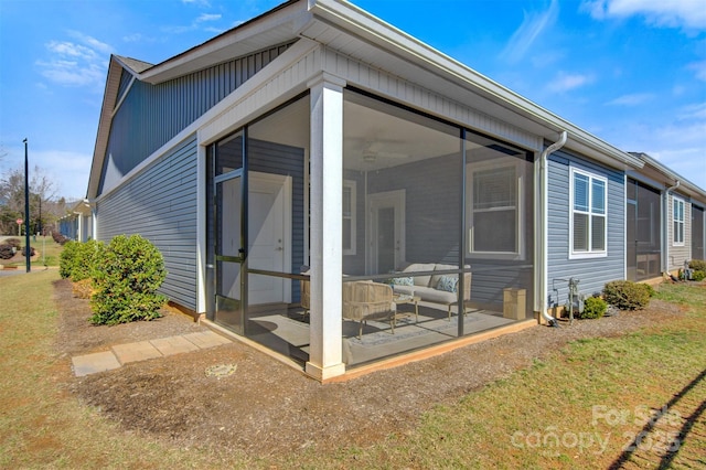 back of property with a yard and a sunroom