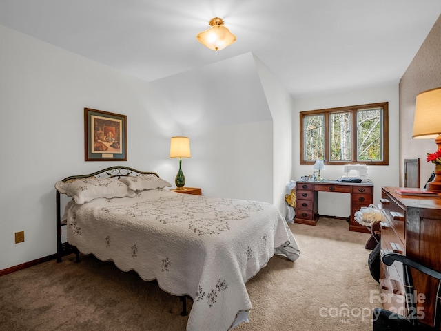 bedroom featuring baseboards, vaulted ceiling, and light colored carpet