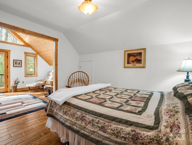 bedroom with vaulted ceiling and wood finished floors