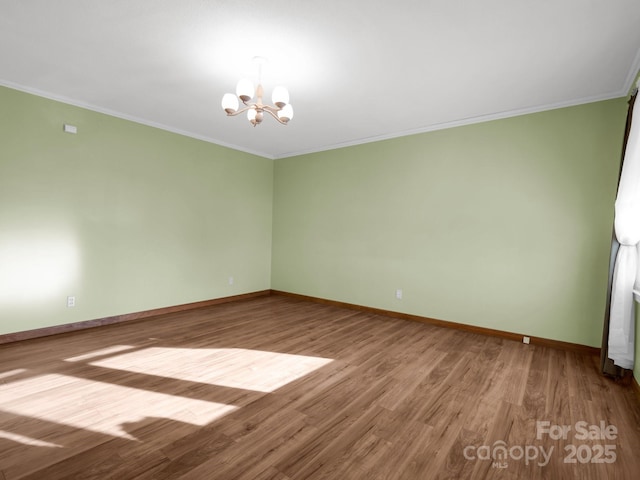 empty room featuring ornamental molding, an inviting chandelier, and wood-type flooring