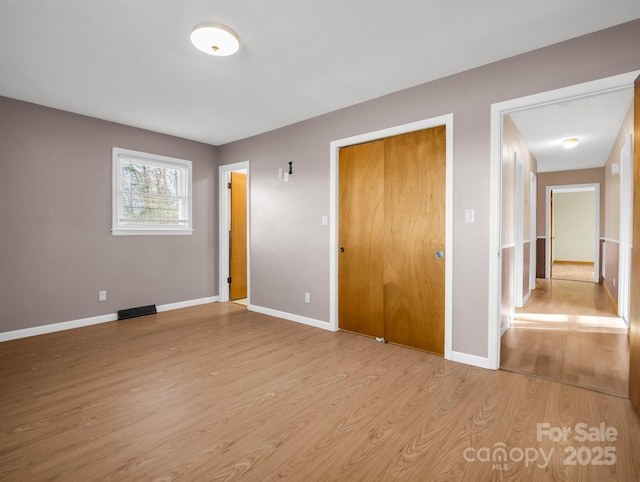 unfurnished bedroom featuring a closet and light hardwood / wood-style floors