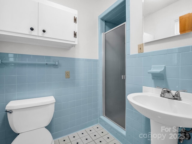 bathroom with tile walls, tile patterned flooring, toilet, and walk in shower