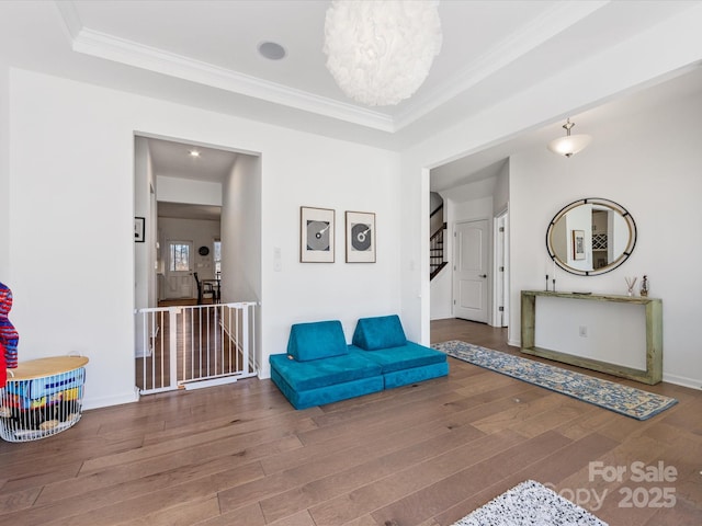 living area with baseboards, dark wood finished floors, stairway, crown molding, and an upstairs landing