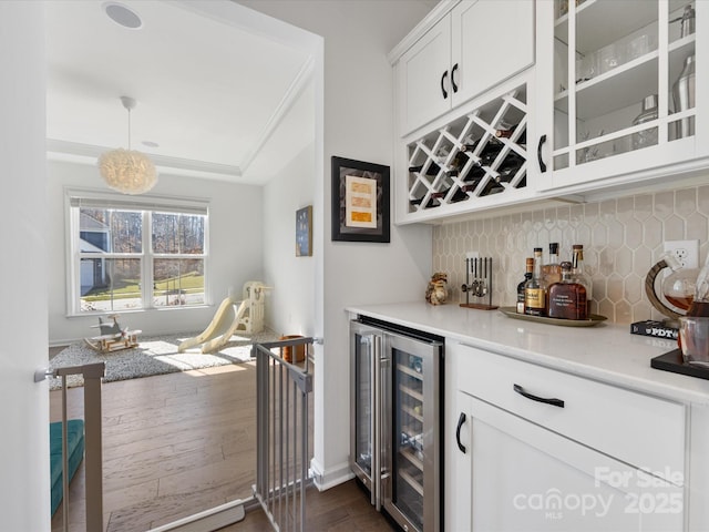 bar featuring a bar, tasteful backsplash, wine cooler, and hanging light fixtures